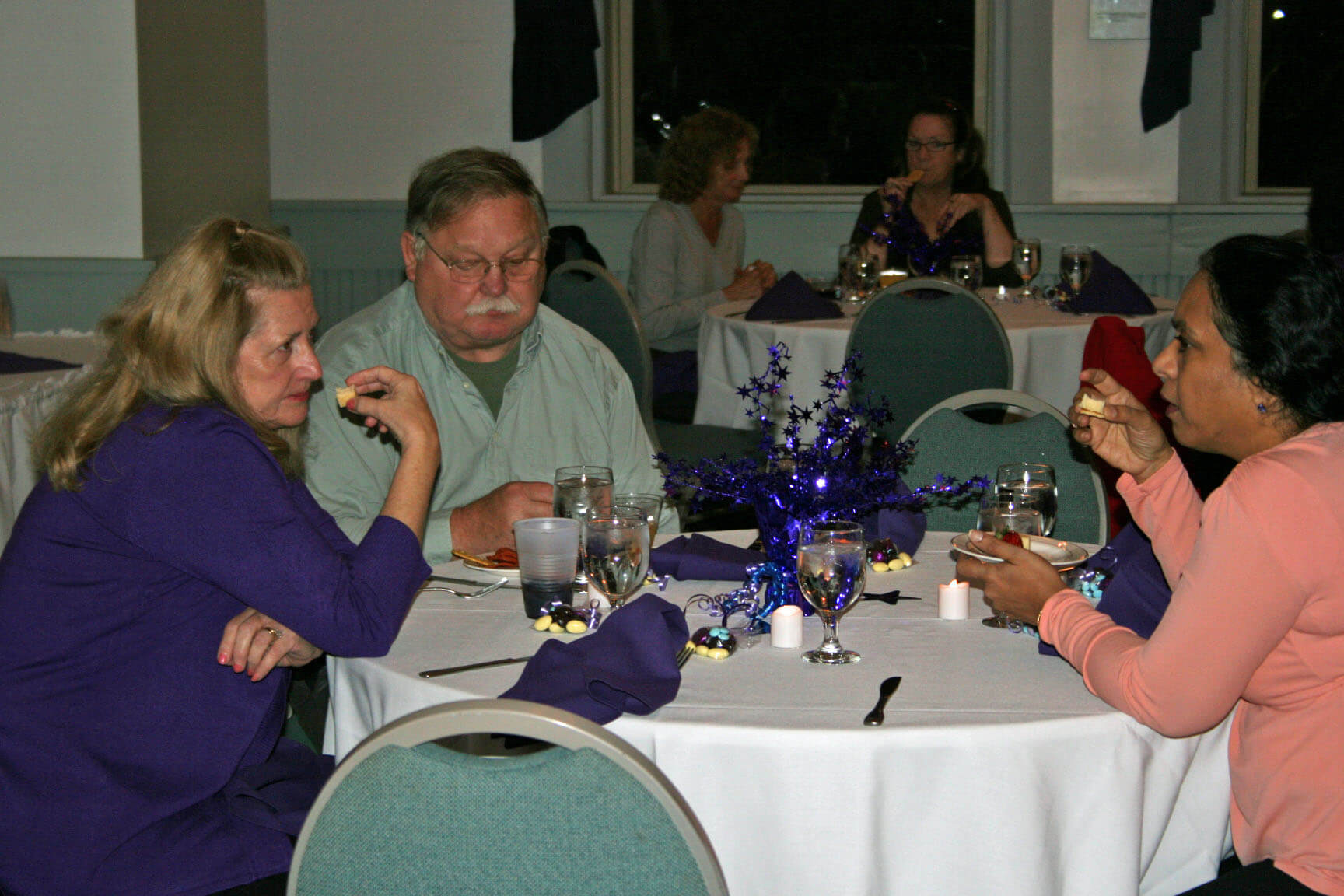 Elaine Kuzmeskus (left) with her husband and Usha Kumar (right) deep in conversation.